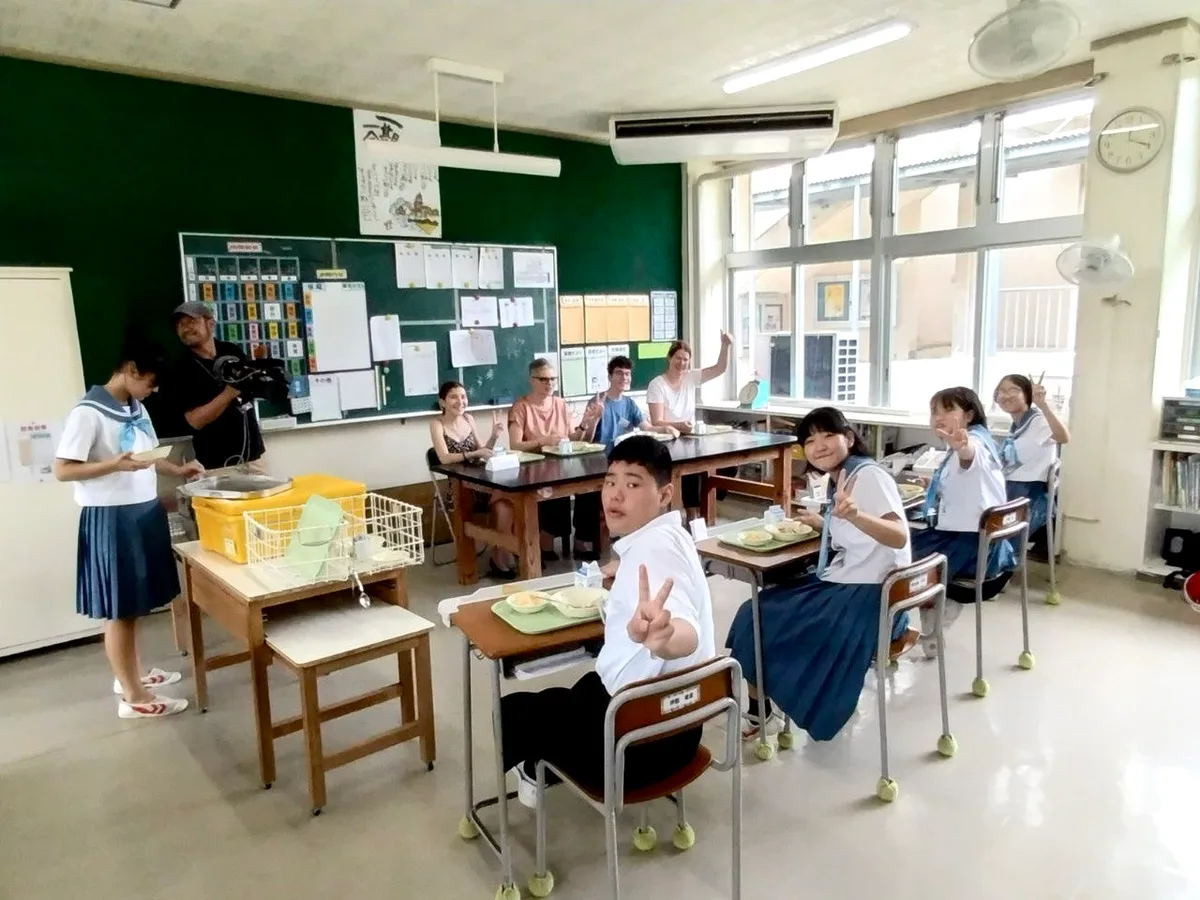 In einem Klassenzimmer sitzen Schülerinnen und Schüler hinter Einzelpults. 